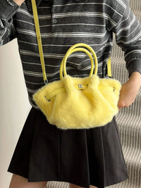 Person holding a yellow fluffy handbag with a striped shirt and black skirt.