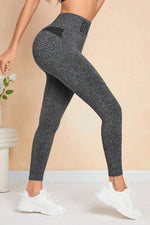 Person wearing dark gray leggings with a beige background