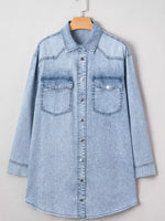 Light blue denim shirt on a hanger against a white background