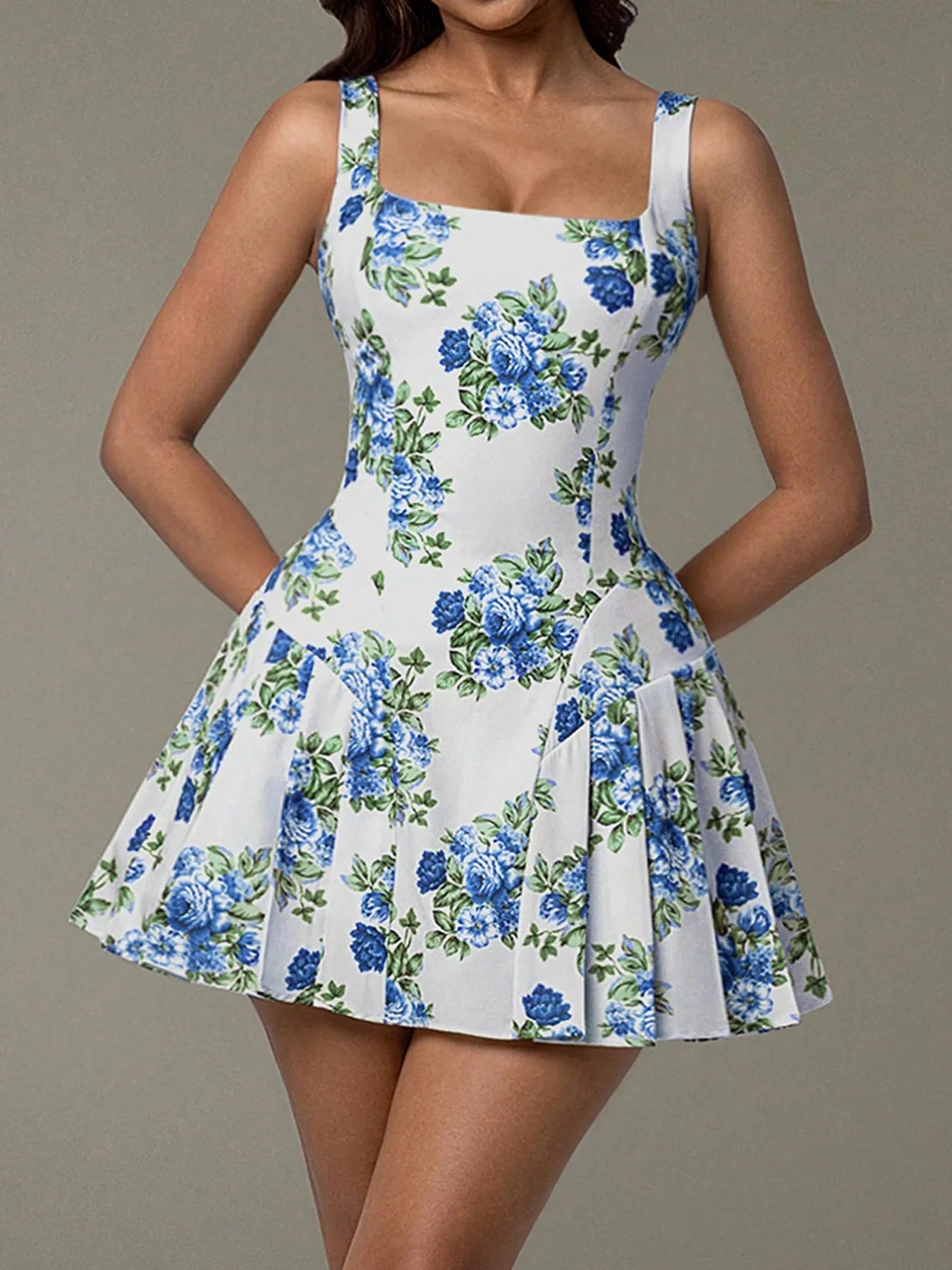 White dress with blue floral pattern worn by a model on a gray background