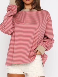 Person wearing a pink and red striped long-sleeve top on a white background