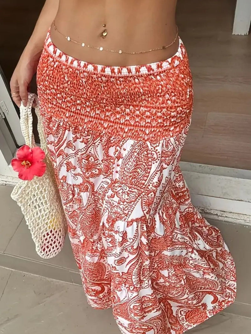 Person wearing a red and white patterned skirt with a pink flower and white bag.