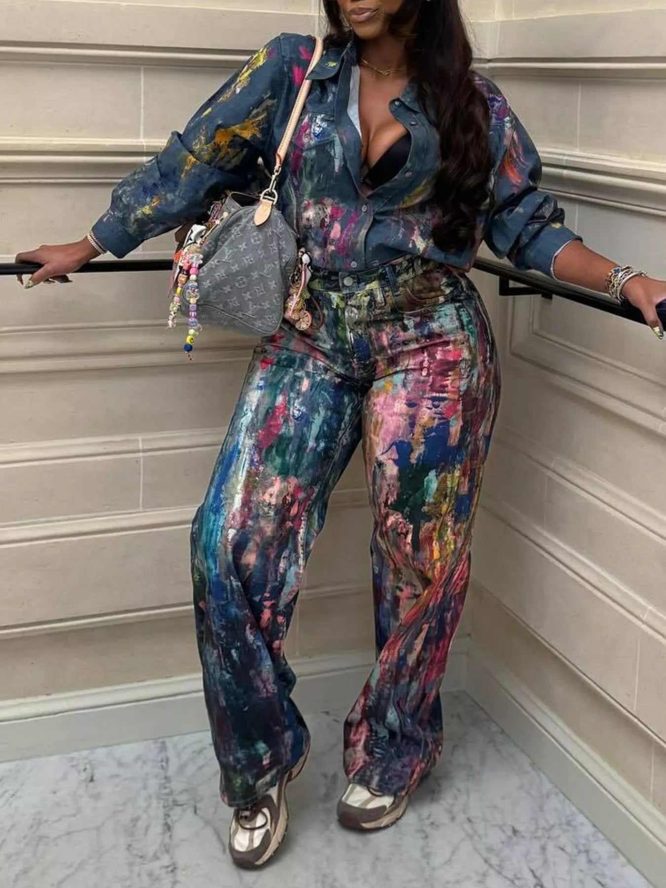 Person wearing a colorful outfit with a textured wall background