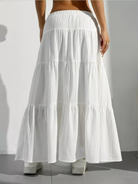 White tiered skirt worn by a person on a plain background