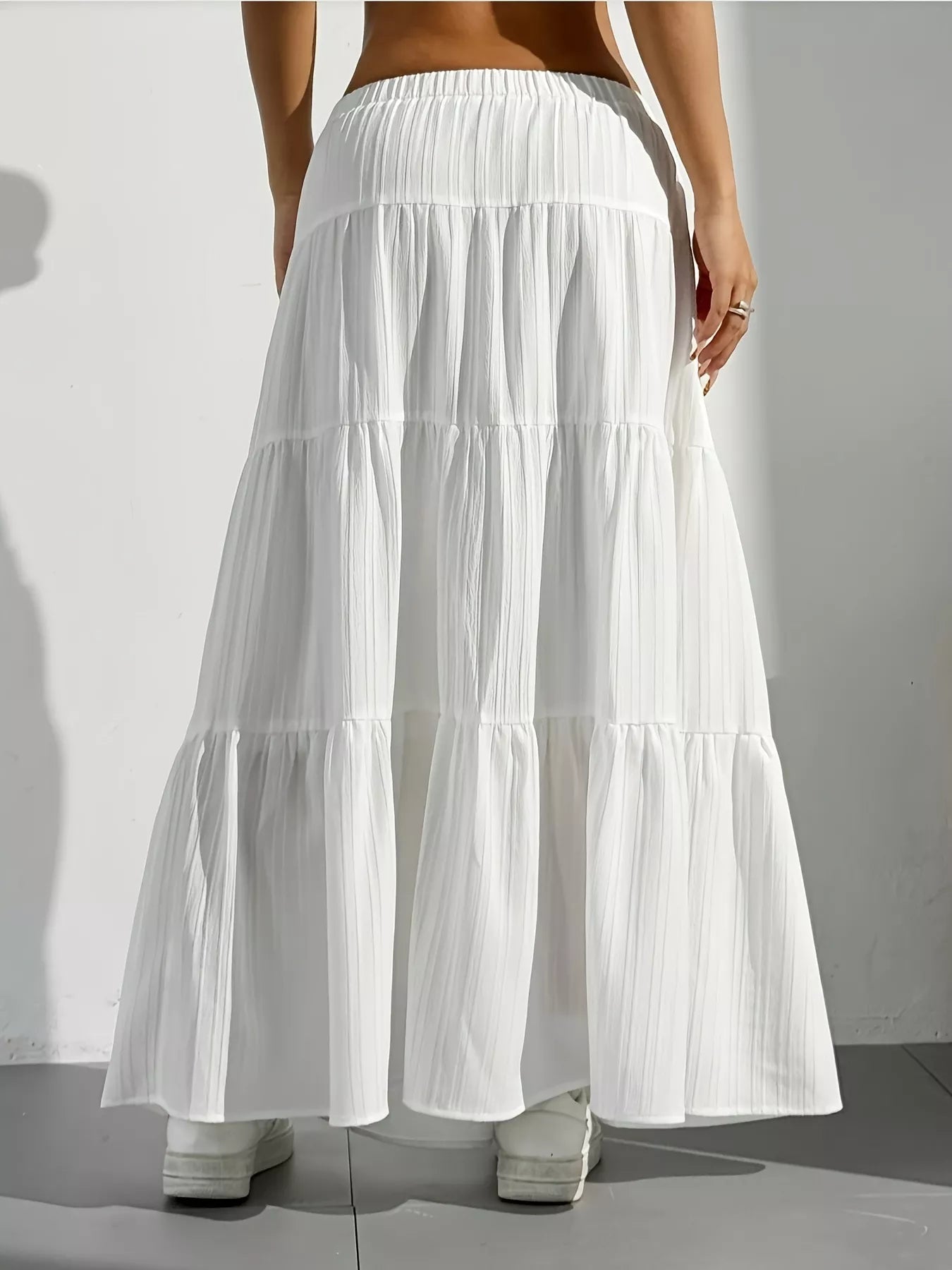 White tiered skirt worn by a person on a plain background