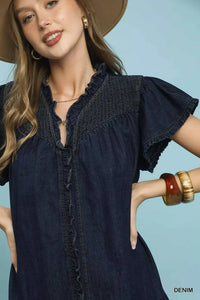 Woman wearing a denim dress with a plain background