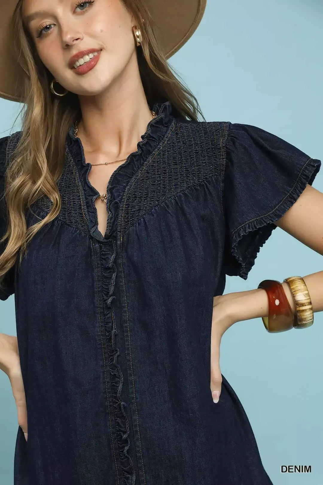 Woman wearing a denim dress with a plain background