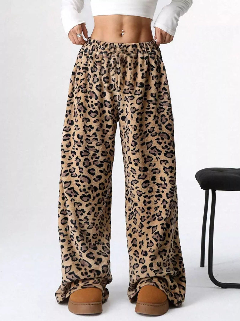 Leopard print pants worn with a white crop top on a white background