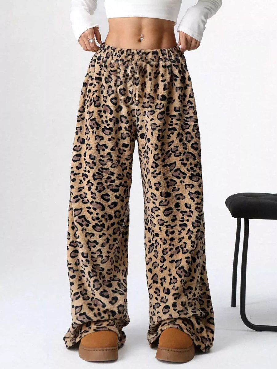 Leopard print pants worn with a white crop top on a white background