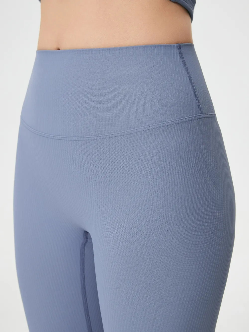 Blue ribbed leggings on a plain background