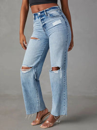 Light blue distressed jeans worn by a person on a gray background