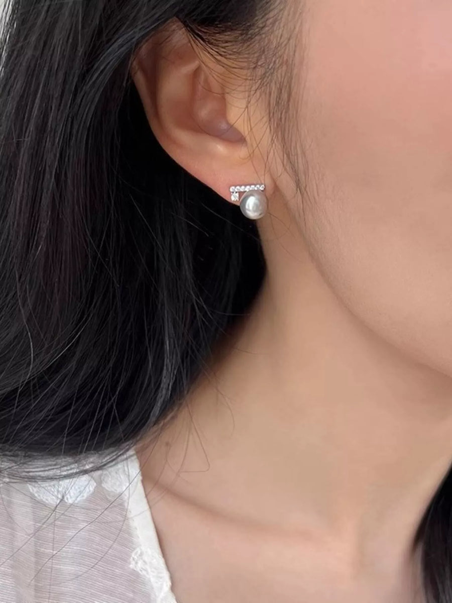 Close-up of an ear wearing a pearl earring with a blurred background