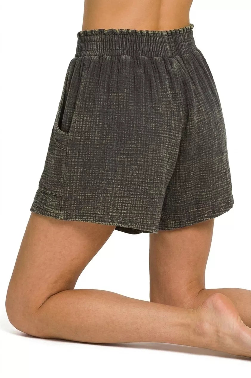 Person wearing dark gray shorts on a white background