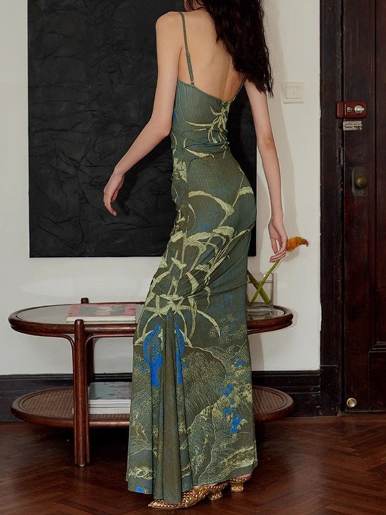 Woman wearing a green floral dress in an indoor setting