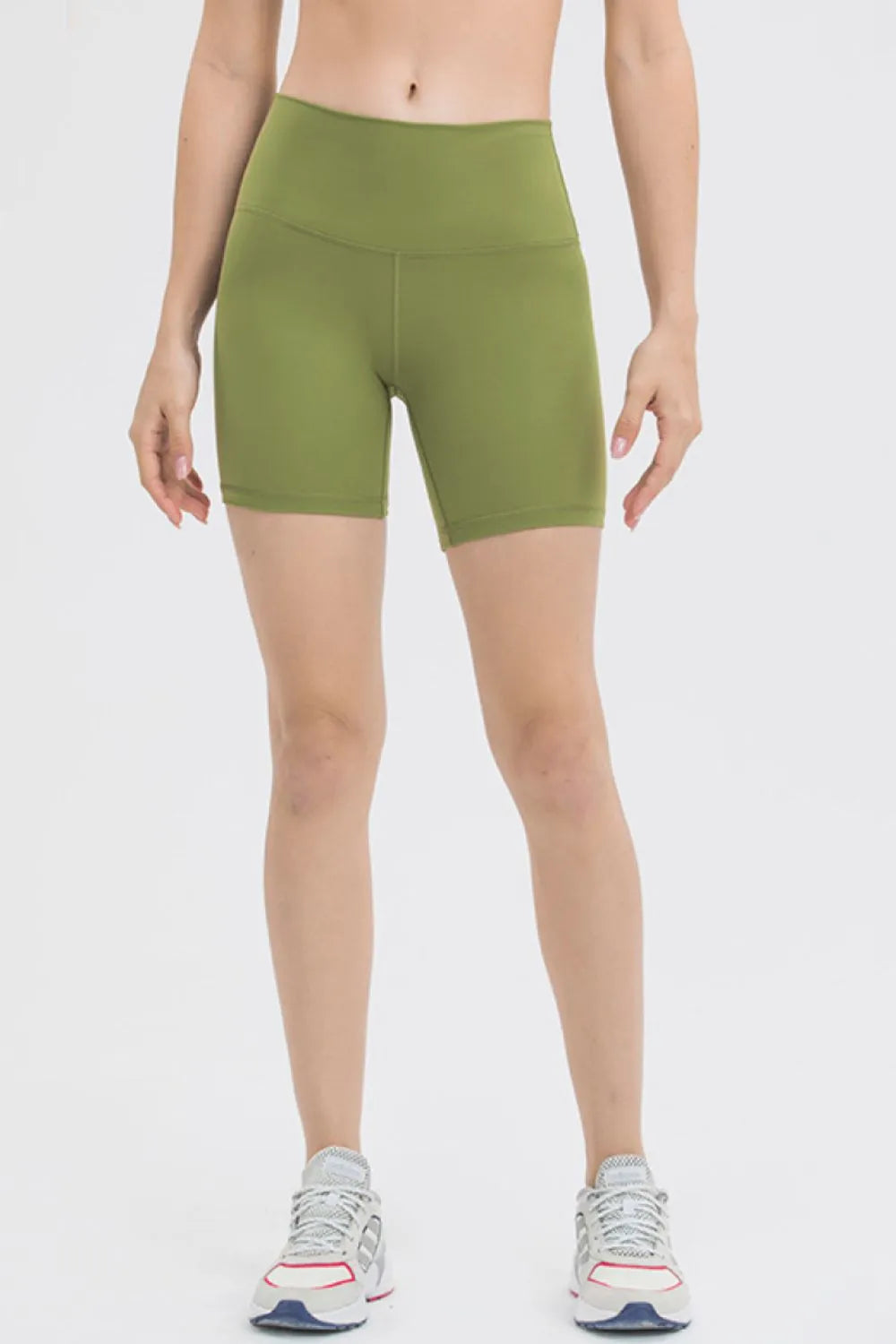 Person wearing green athletic shorts on a white background