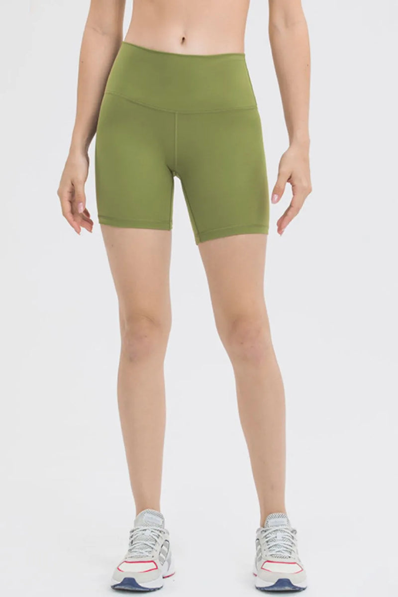 Person wearing green athletic shorts on a white background