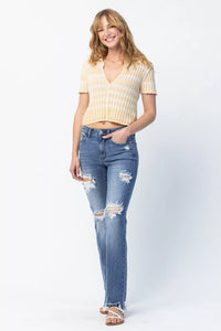 Woman wearing a yellow striped shirt and blue jeans on a white background