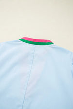 Light blue shirt with a colorful collar on a beige background