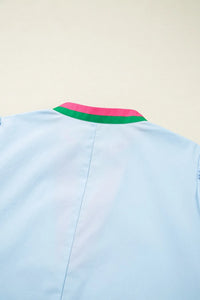 Light blue shirt with a colorful collar on a beige background