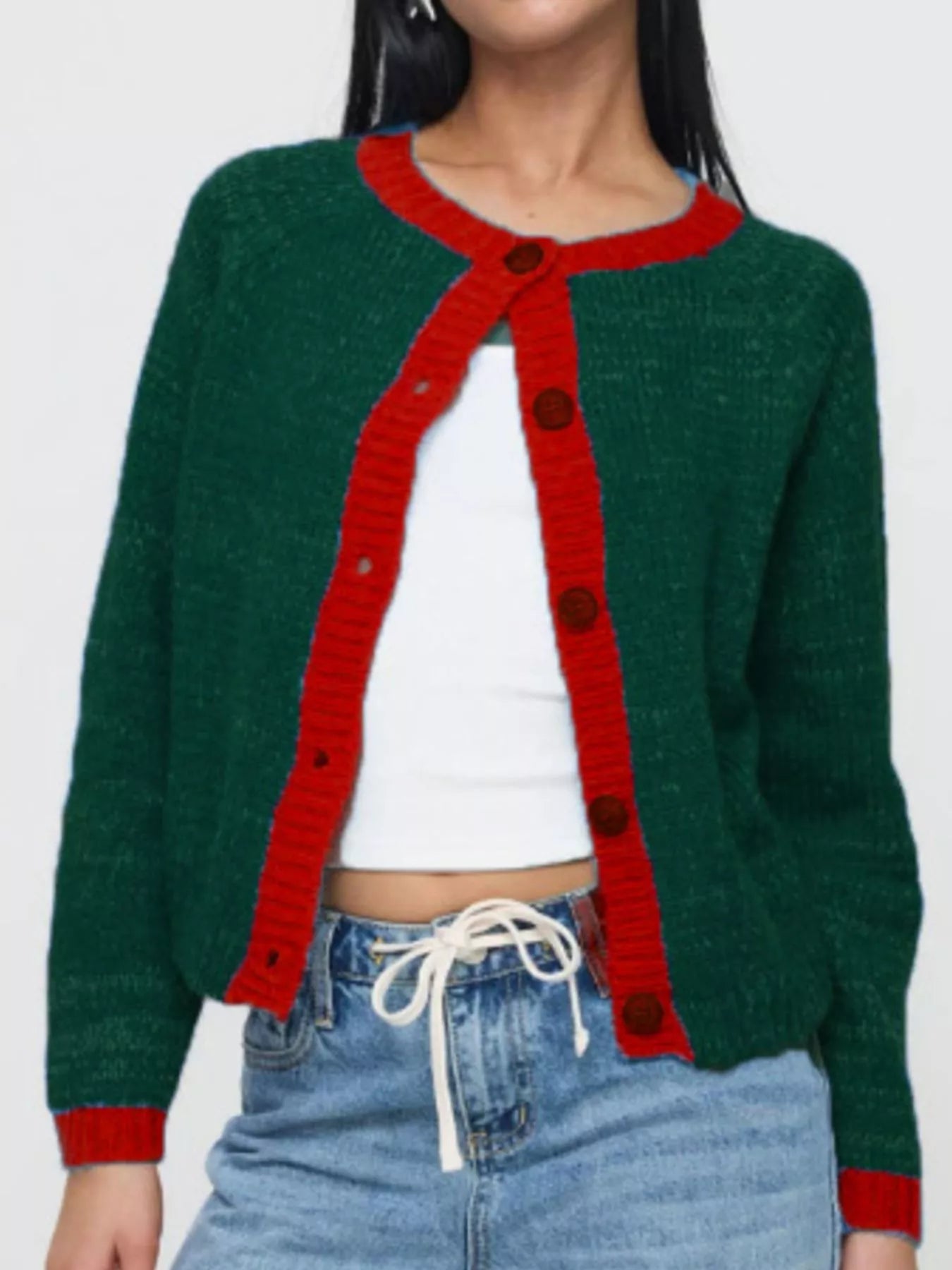 Green cardigan with red trim worn by a person on a white background