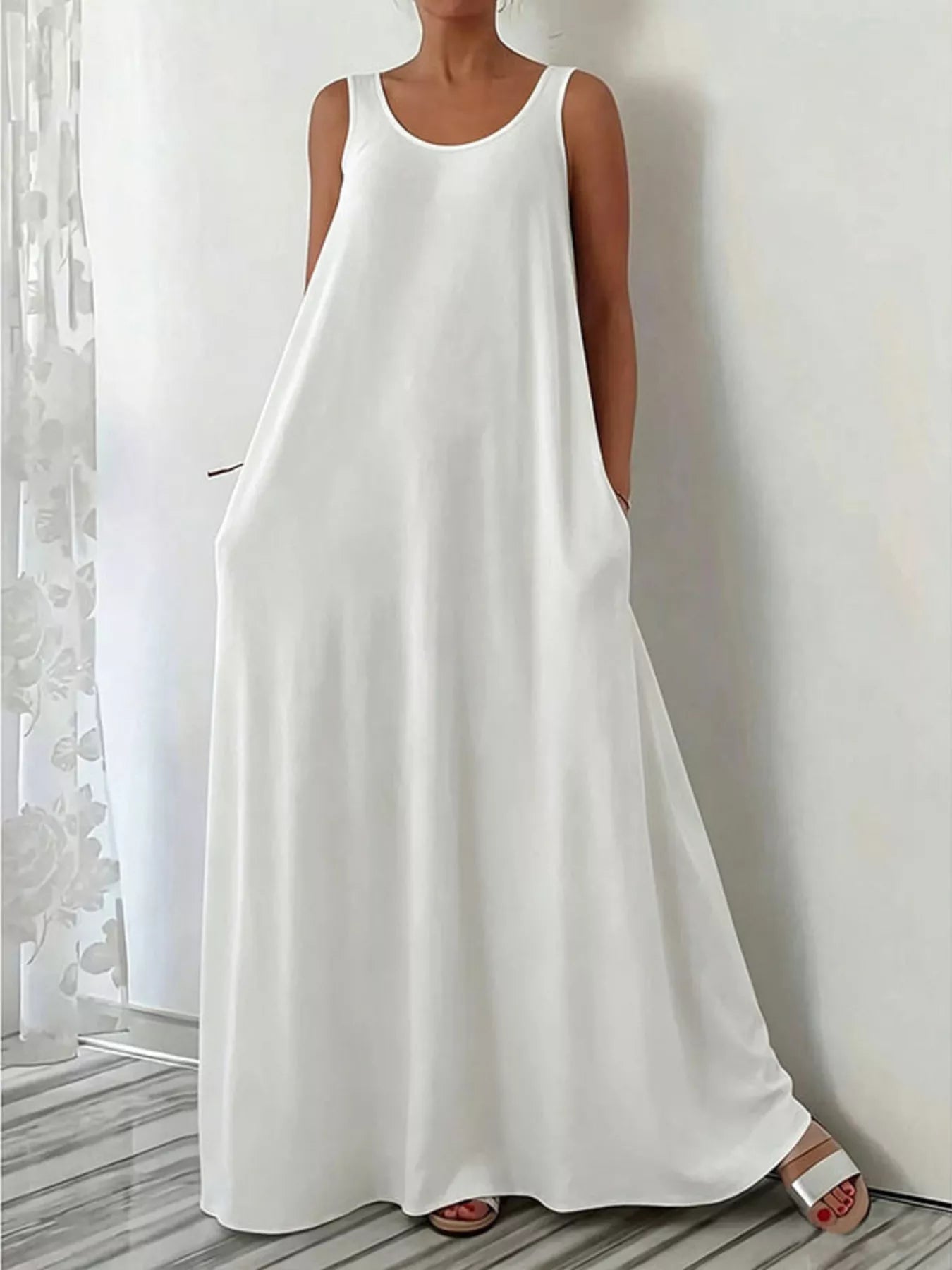 Woman wearing a white sleeveless dress against a neutral background