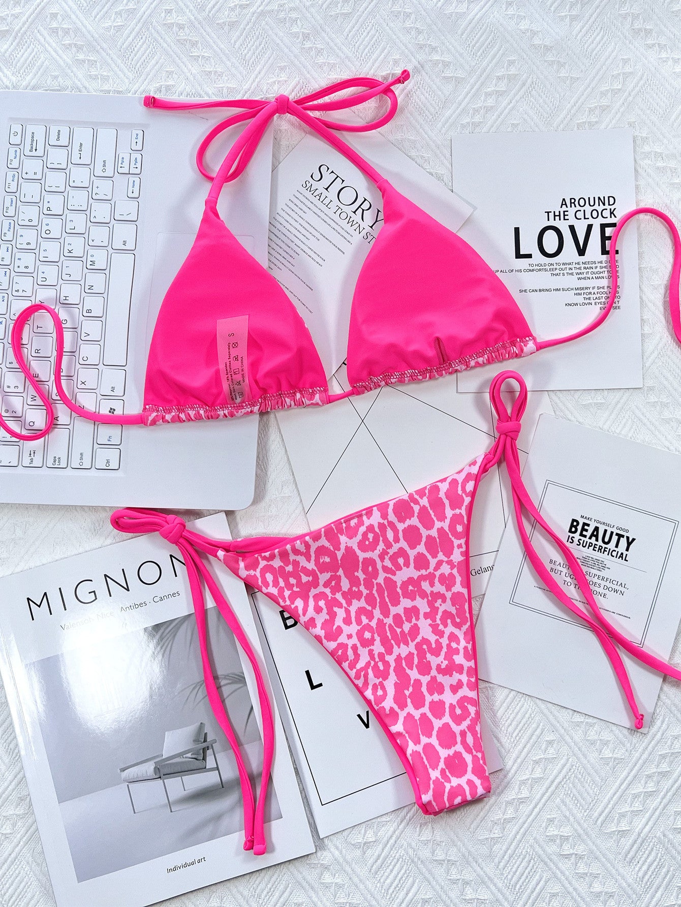 Pink bikini set with leopard print bottom on a magazine background