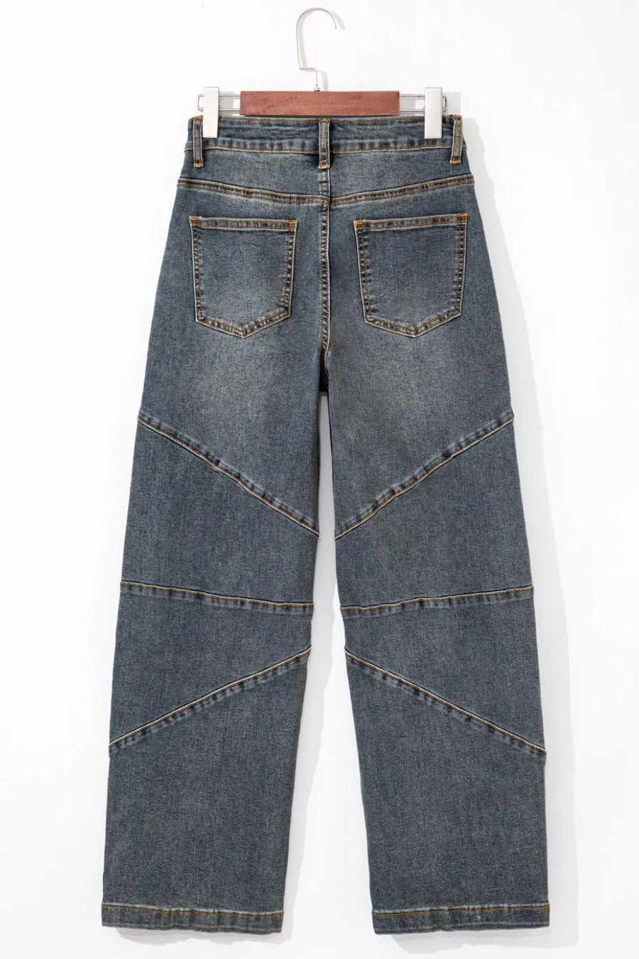 Blue jeans on a hanger against a white background