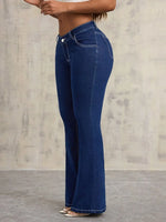 Person wearing blue jeans against a neutral background