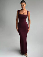 Woman wearing a burgundy evening gown against a gray background