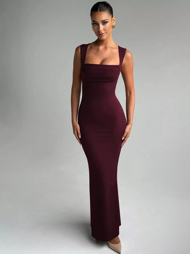 Woman wearing a burgundy evening gown against a gray background