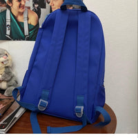 Blue backpack on a wooden surface with a light-colored wall in the background