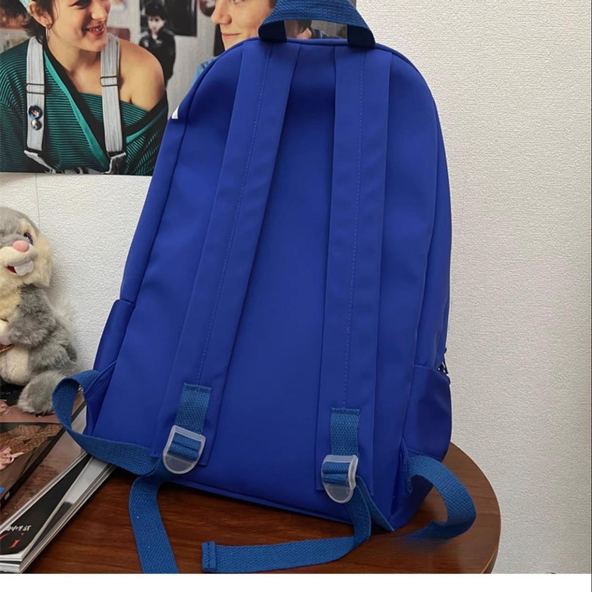 Blue backpack on a wooden surface with a light-colored wall in the background