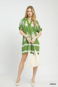 Woman wearing a green dress with white patterns on a white background
