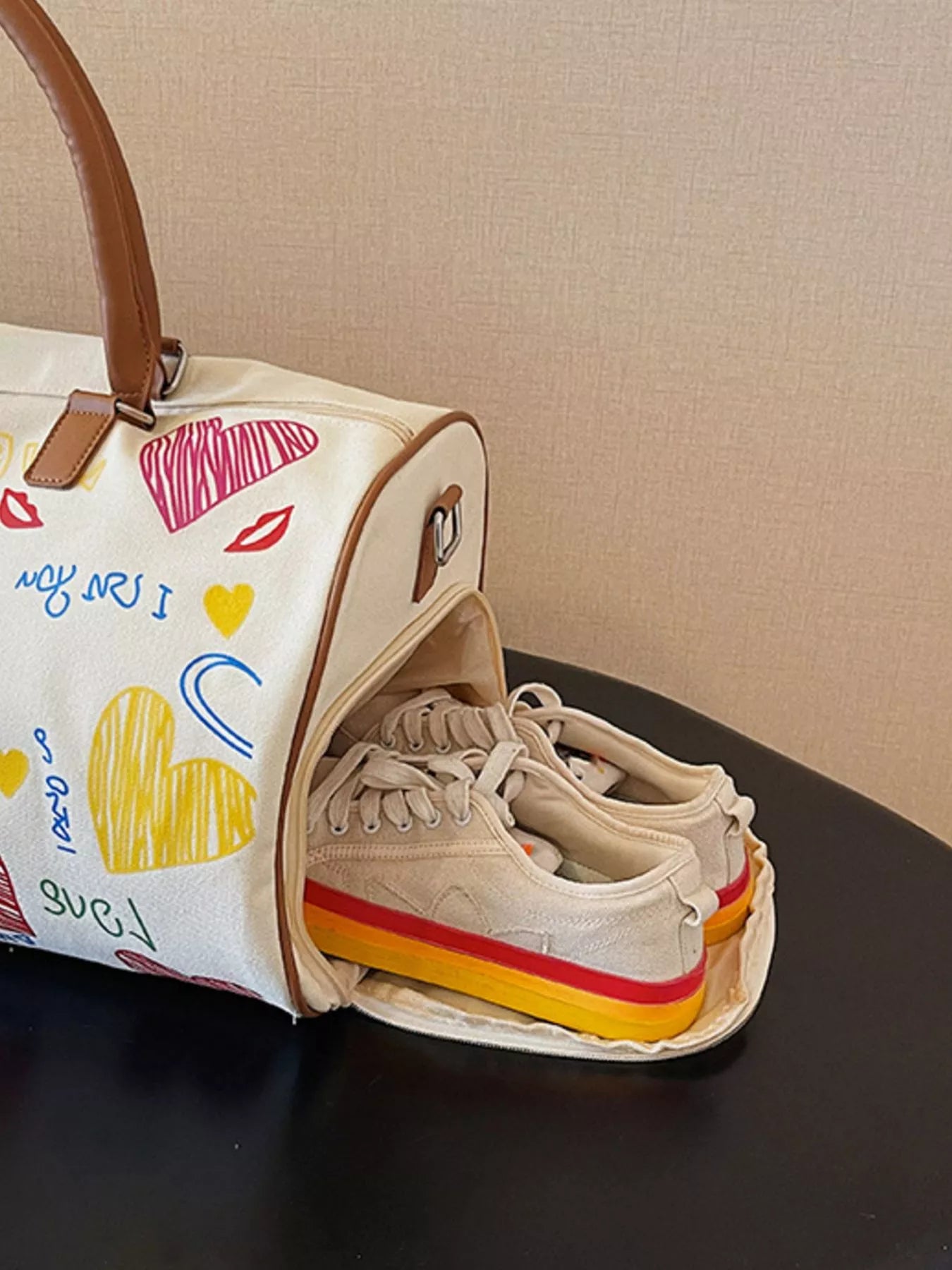 Canvas bag with colorful designs and a sneaker inside on a dark surface.