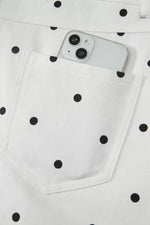 White polka dot jeans with a smartphone in the pocket