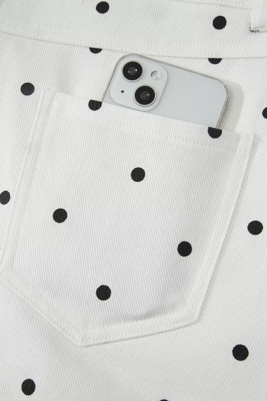 White polka dot jeans with a smartphone in the pocket