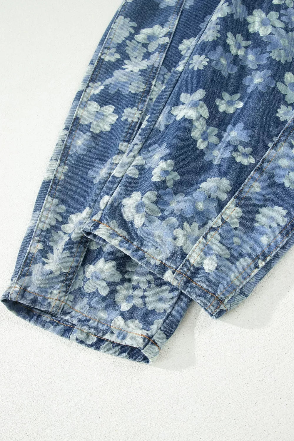 Blue floral-patterned jeans on a white background