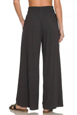 Black wide-leg pants worn by a person on a white background