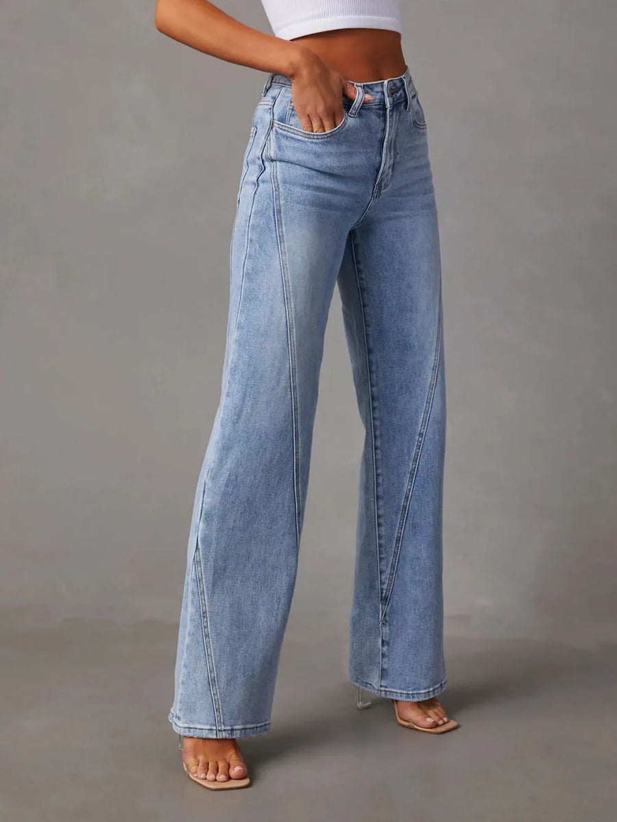 Light blue jeans worn by a person on a gray background