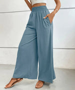 Person wearing blue wide-leg pants against a white background