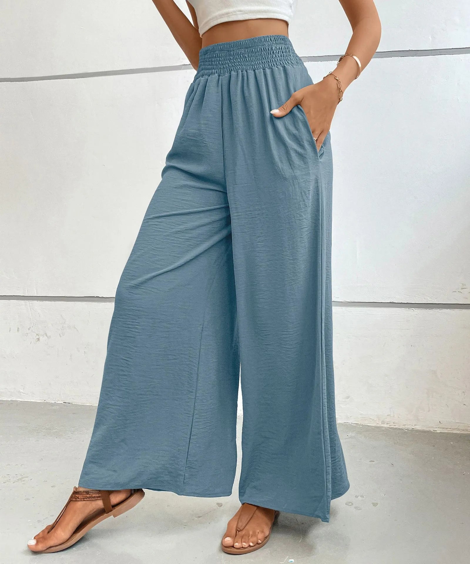 Person wearing blue wide-leg pants against a white background