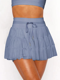 Blue tiered skirt worn by a person on a white background