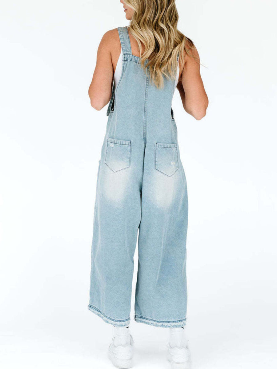 Light blue denim overalls worn by a person on a white background