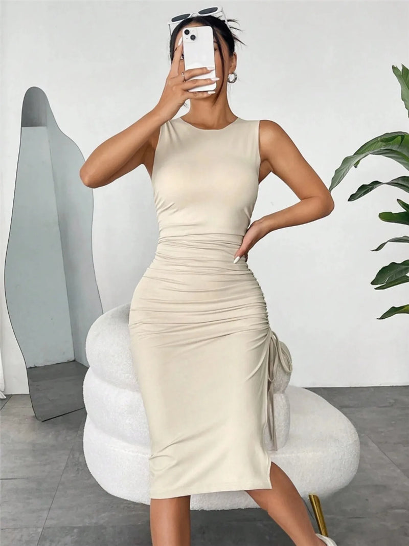Woman taking a mirror selfie wearing a beige sleeveless dress in a modern room.