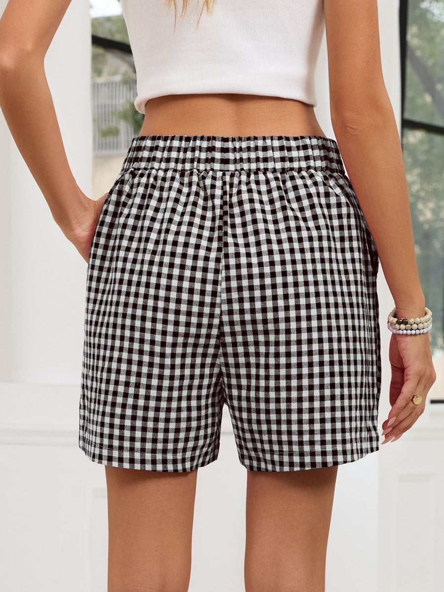 Person wearing black and white checkered shorts with a blurred background