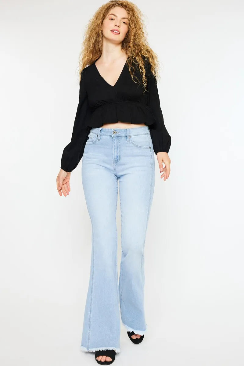 Woman wearing a black sweater and light blue jeans on a white background
