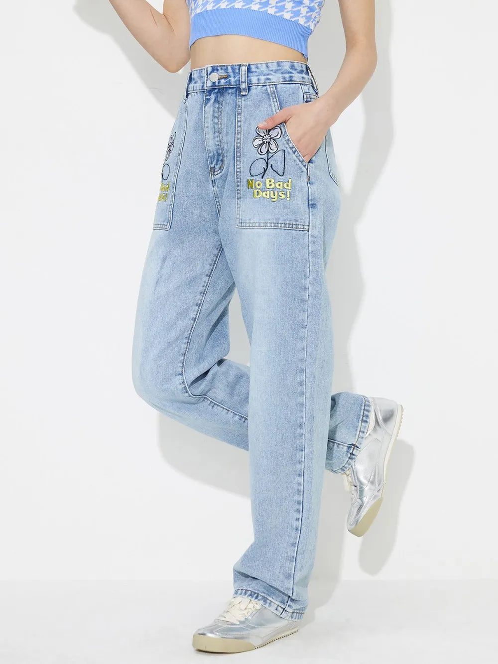 Person wearing light blue jeans with a brand logo on a white background
