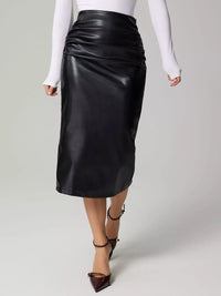 Black leather skirt worn by a person on a gray background