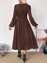 Brown dress worn by a person with a white wall and decorative elements in the background