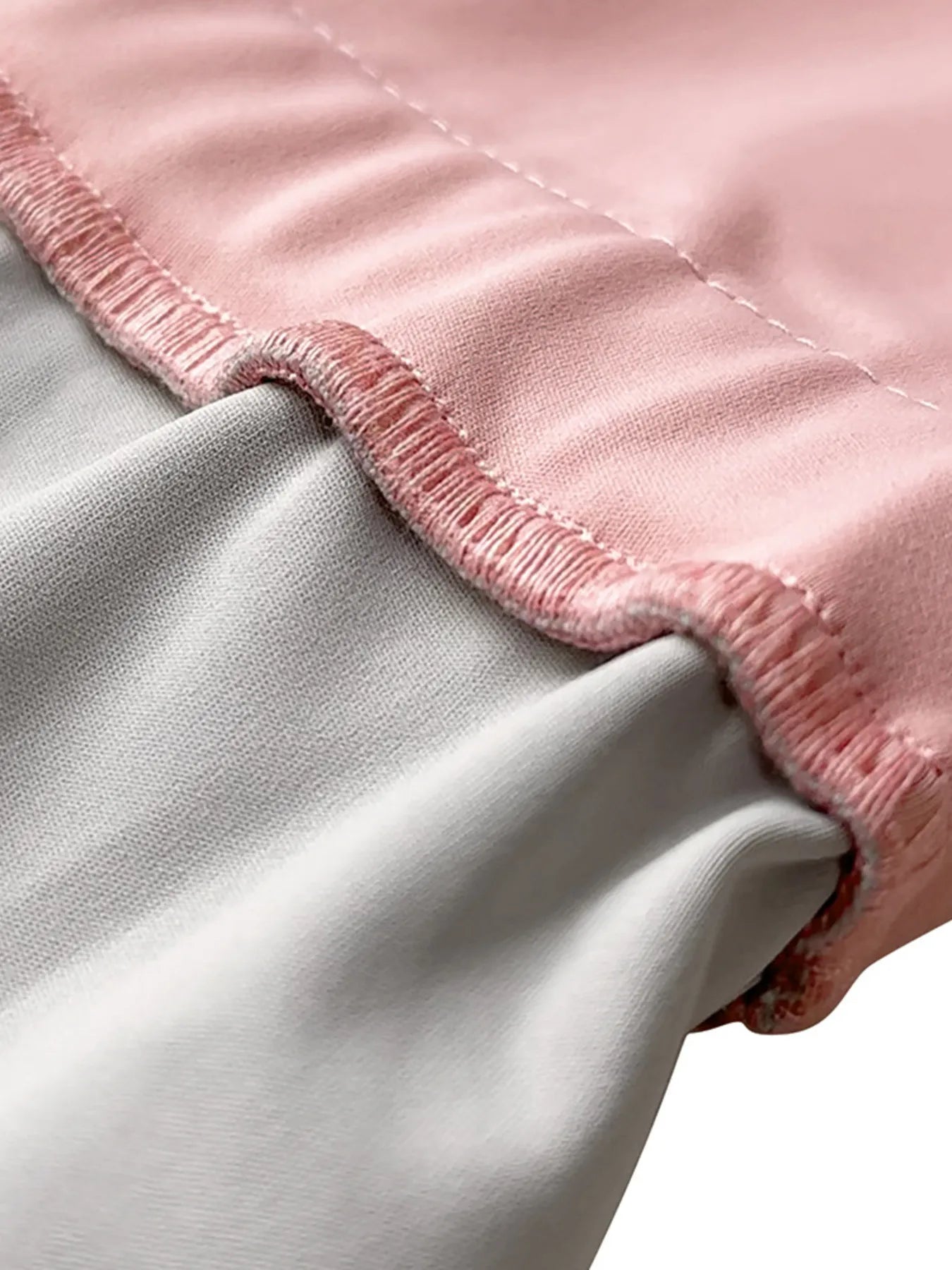 Close-up of a pink and gray blanket with frayed edges.